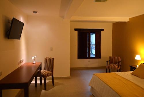 a bedroom with a desk and a bed and a table at Posada de los Poetas Hotel Boutique in San Lorenzo