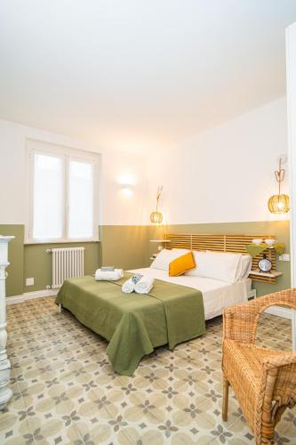 a bedroom with two beds and a chair at H H Moneglia il Vicolo in Moneglia