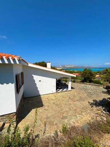 a white house with the ocean in the background at Villa Haass in Stintino