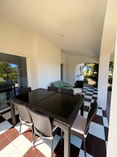 a dining room with a black table and chairs at Villa Haass in Stintino