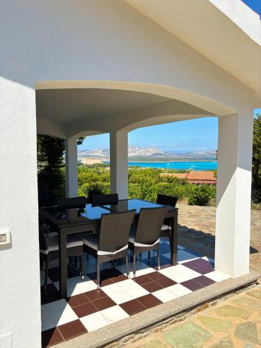a patio with a table and chairs on a checkered floor at Villa Haass in Stintino
