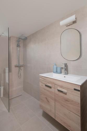 Un baño con lavabo y ducha con espejo. en Amazing Sea View and Location, en Scala