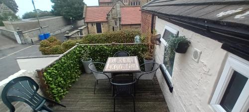 a table and chairs sitting on a balcony with stairs at Heart of Filey in Filey