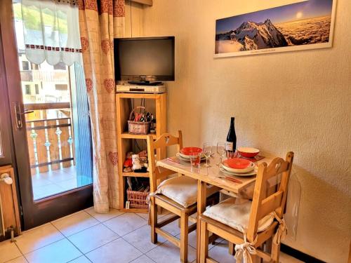 une salle à manger avec une table et une télévision dans l'établissement Studio au pied des pistes avec Wifi, animaux acceptés - FR-1-598-86, aux Gets