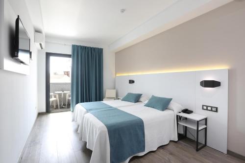 a hotel room with a bed and a large window at Hotel Alameda in Benidorm