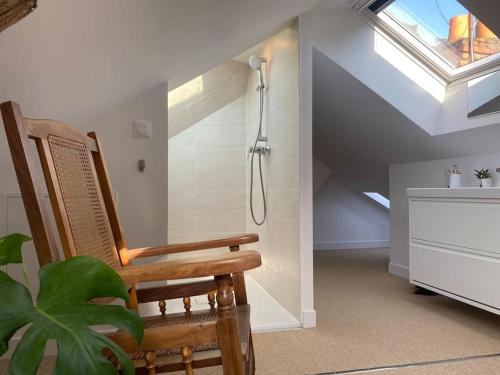 La salle de bains est pourvue d'une douche et d'une chaise en bois. dans l'établissement Duplex cinéma - centre historique Tours, à Tours
