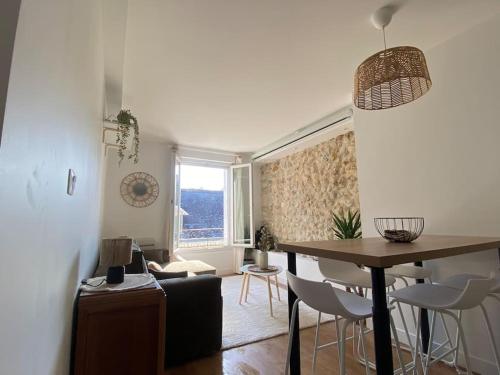 un salon avec une table et des chaises et un salon dans l'établissement Duplex cinéma - centre historique Tours, à Tours