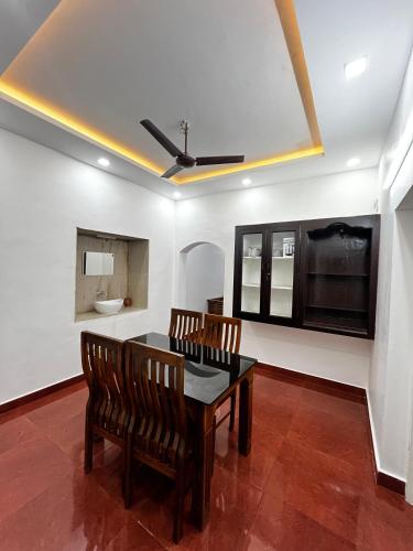 a dining room with a table and chairs and a toilet at The Signature Suites in Edappally