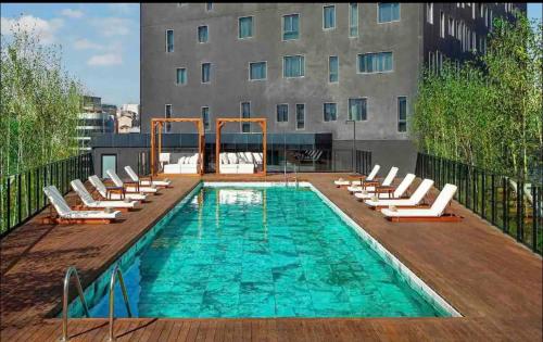 a swimming pool with lounge chairs and a building at huzurlu ve şirin in Istanbul