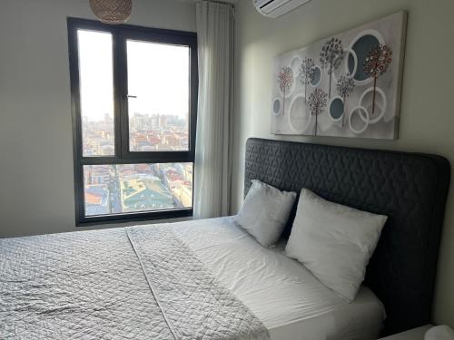 a bedroom with a bed with a large window at huzurlu ve şirin in Istanbul