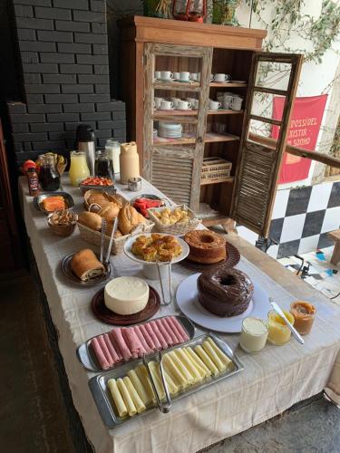 un tavolo pieno di diversi tipi di pane e dolci di Pousada e Hostel Mandala Ibitipoca a Conceição da Ibitipoca
