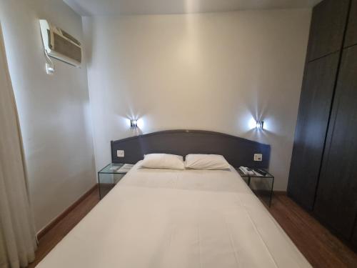 a bedroom with a bed with two glass tables at Max Savassi Luxury in Belo Horizonte