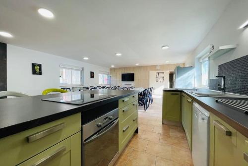 a large kitchen with yellow and green counter tops at Grand gîte dans un écrin de verdure au bord du Cher in Azay-sur-Cher