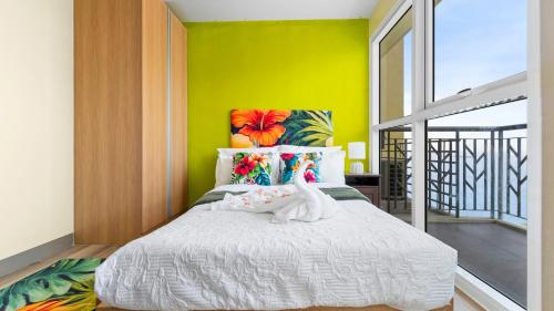 a bedroom with a white bed with a yellow wall at Luxury Condo Ocean View 1,2,3, & 4 Bedrooms Infinity Pool Gym Spa Next to Okada Solaire MOA NAIA Airport in Manila