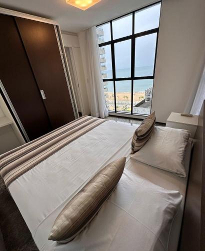a bedroom with a large bed with a pillow on it at Hotel Brasil Tropical in Fortaleza