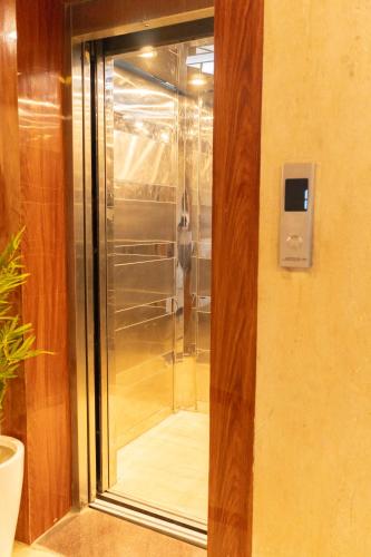 a glass shower in the corner of a room at Rosewood at Rajpur Road by Zenvana in Rājpur