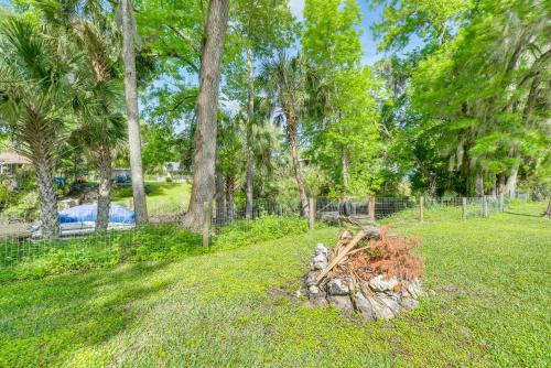 a pile of logs in a yard with trees at Withlacoochee River Rental with Dock Access! in Yankeetown