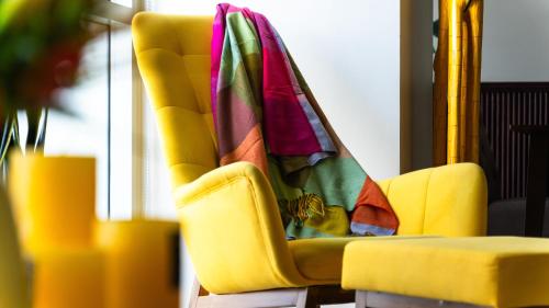 a yellow chair with a blanket on top of it at Luxury Condo Ocean View 1,2,3, & 4 Bedrooms Infinity Pool Gym Spa Next to Okada Solaire MOA NAIA Airport in Manila