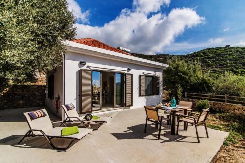 a patio with chairs and a table in front of a house at Christos Place-Anidri in Palaiochóra