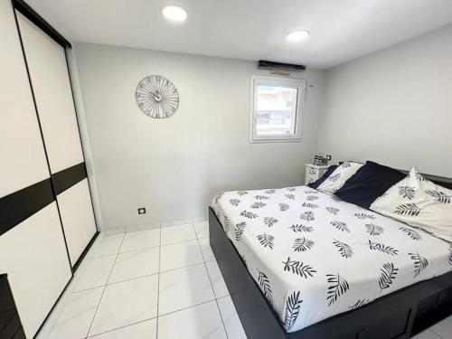 une chambre avec un lit et une horloge au mur dans l'établissement Superbe Appartement avec terrasse 2 chambres, 4 à 5 couchages piscine, à deux pas des plages et de la Croisette, à Cannes