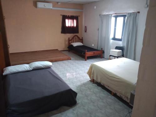 a hotel room with two beds and a couch at Atenea Departamentos Temporarios in Villa María