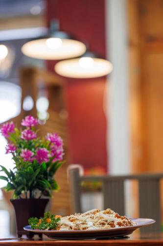 uma pizza num prato sobre uma mesa com flores em Hotel Qualitel Plus em Morelia