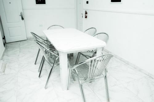 a white table and chairs in a kitchen at UNIA Homes in Benin City