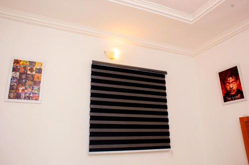 a room with a white wall with a window and pictures at UNIA Homes in Benin City