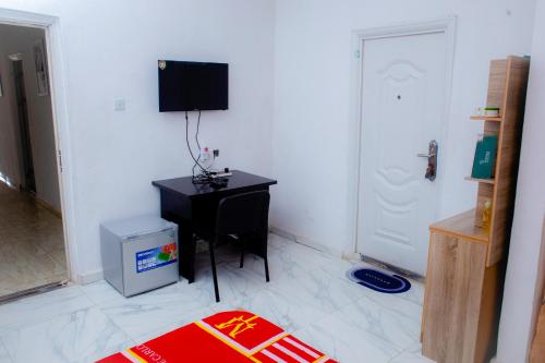 a room with a desk and a television on a wall at UNIA Homes in Benin City