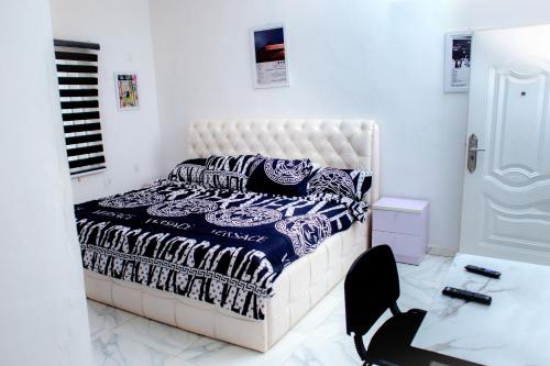 a bedroom with a bed and a chair in it at UNIA Homes in Benin City