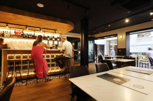 a woman standing at a bar in a restaurant at Hotel Alameda in Benidorm