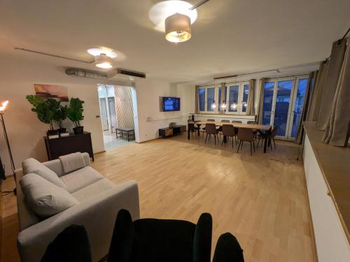 Munich Large Apartment 150 qm in top located with 4 Bedrooms 1 to 15 guests في ميونخ: غرفة معيشة بها أريكة وطاولة