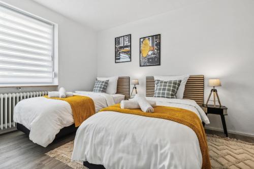 deux lits dans une chambre aux murs blancs dans l'établissement Stylish Family & Business Apartment in Homburg - nahe Uniklinik - ruhig gelegen - 3 SZ - bis zu 6 Pers - Balkon - Badewanne - WLAN 250 Mb - Parkplätze - Self-Check-in, à Hombourg