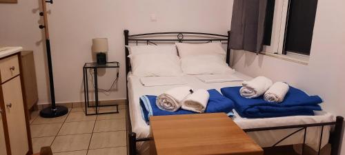 a bedroom with a bed with towels on it at Πλάτανος Στούντιο ΙΙ Platanos studio II in Mytilene