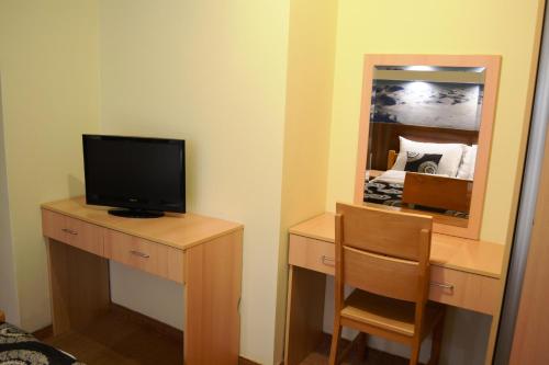 a room with a desk with a television and a mirror at Guesthouse Lucic in Jahorina
