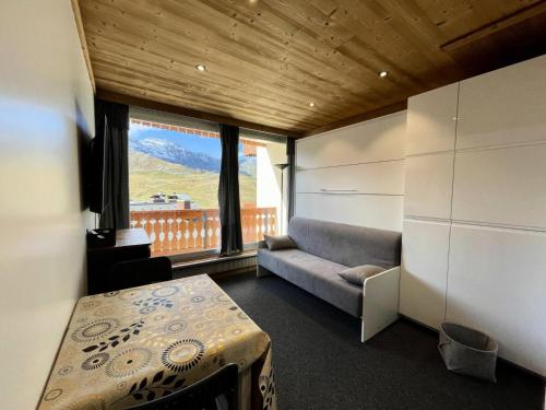 une chambre avec un canapé, une table et une fenêtre dans l'établissement Résidence Dome De Polset - VAL THORENS location: studio rénové et ensoleillé avec vue sur les montagnes MAE-9125, à Val Thorens