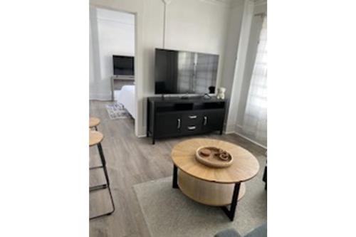 a living room with a coffee table and a flat screen tv at Modern Unit 212 in a 1930s Building in Klamath Falls