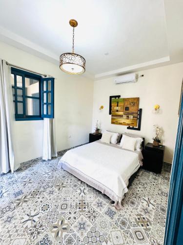 a bedroom with a white bed and a blue floor at Casa Diriangen in Diriamba