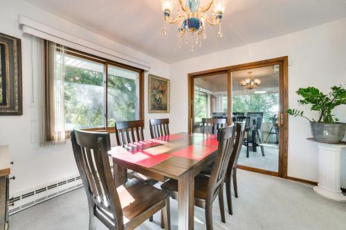 a dining room with a table and chairs and a chandelier at Riverfront Sault Ste Marie Home with Dock! in Sault Ste. Marie