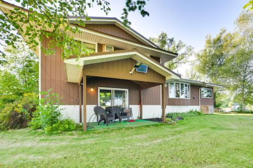 a house with two chairs and a table in the yard at Riverfront Sault Ste Marie Home with Dock! in Sault Ste. Marie