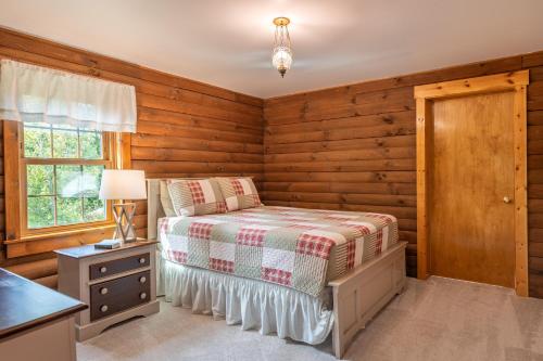 a bedroom with a bed and a table and a window at Maple Leaf Cabin in Millersburg
