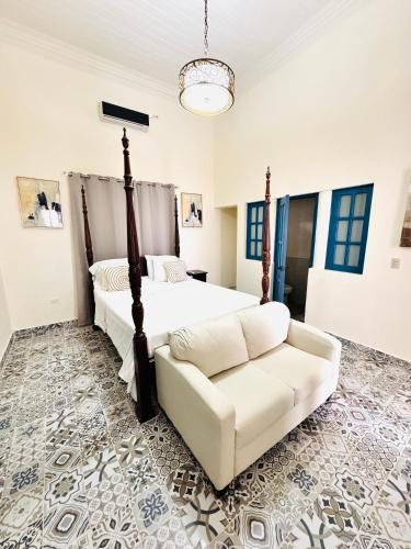 a bedroom with a bed and a white couch at Casa Diriangen in Diriamba