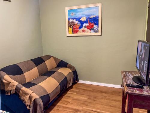 a room with a couch and a picture on the wall at R6 · Uma obra de arte na sua praia in Guarujá