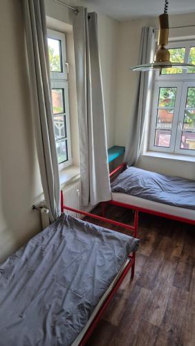 a room with two beds and two windows at Pferdeblick in Dannenberg