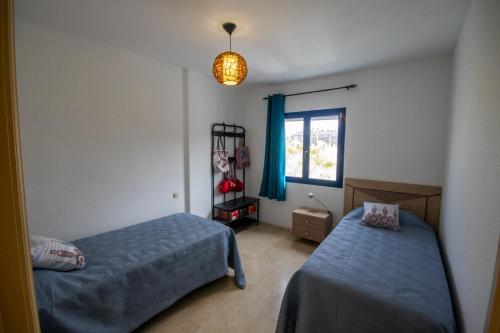 a bedroom with two beds and a window at Casa azul Agaete in Las Palmas de Gran Canaria
