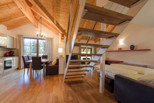 ein Schlafzimmer mit einer Treppe, die zu einem Bett führt, und eine Küche in der Unterkunft Aigenberg Appartements in Flachau