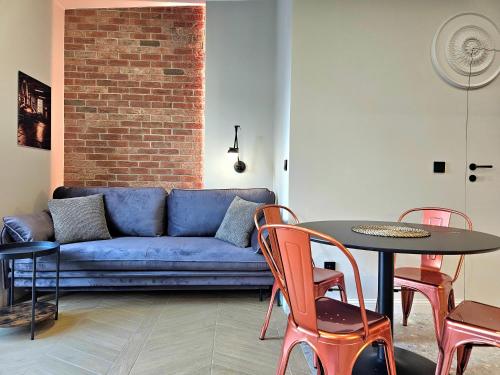 a living room with a blue couch and a table and chairs at ROOSEVELTA RESIDENCE Apartments - przy OFF Piotrkowska in Łódź