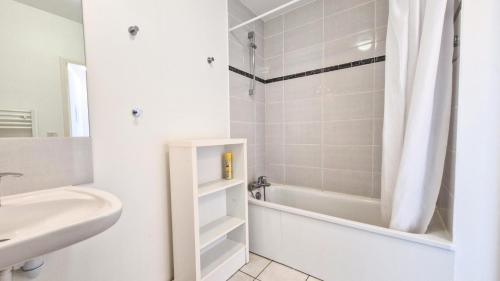une salle de bain blanche avec une baignoire et un lavabo dans l'établissement Résidence Les Pleiades - Appartement lumineux avec parking couvert · Centre station · Balcon MAE-7393, à Flaine