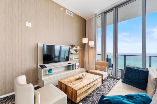 a living room with a couch and a tv at Discover the Magic of Lyfe Resort and Residences in Hollywood