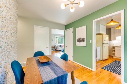 a dining room with a wooden table and blue chairs at Central Boulder Home with Outdoor Oasis, Walk to CU! in Boulder